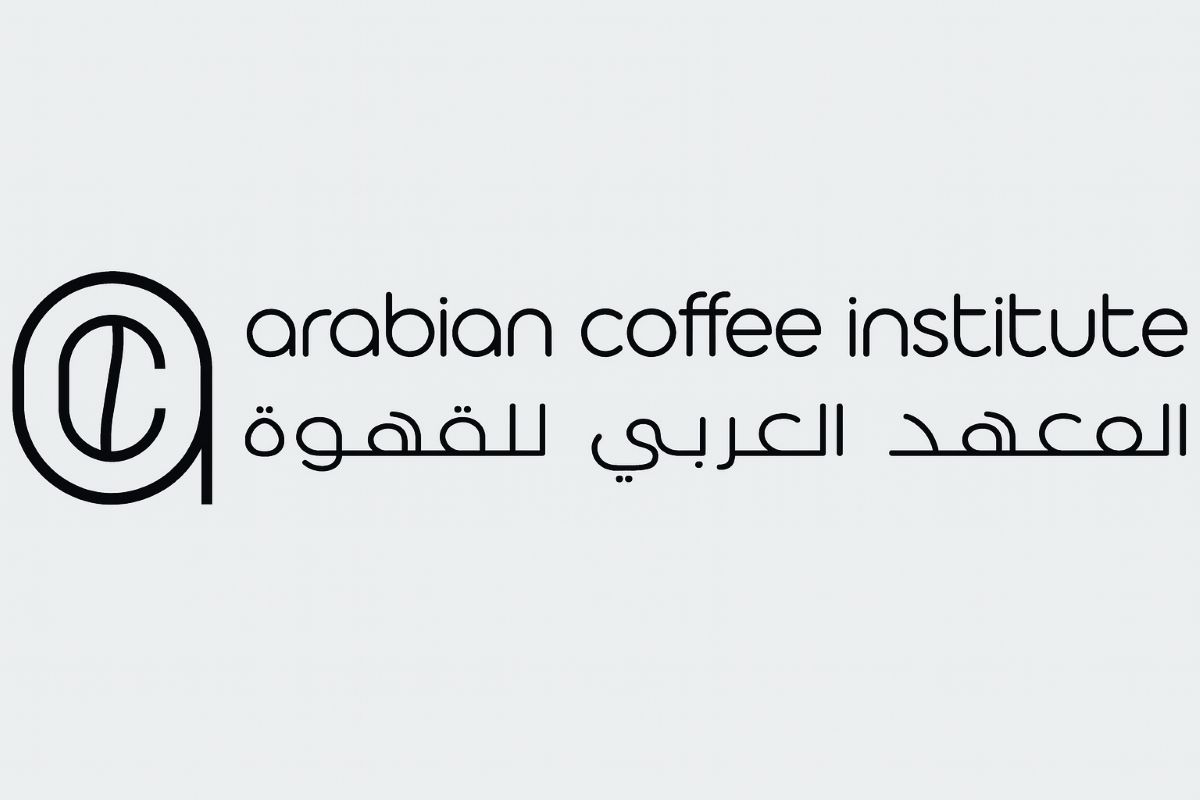 A black-and-white logo of the Arabian Coffee Institute featuring a circular emblem with the stylized letters "A" and "C" on the left, and the institute's name written in both English and Arabic ("arabian coffee institute" and "المعهد العربي للقهوة") in a modern, rounded font on a light gray background.