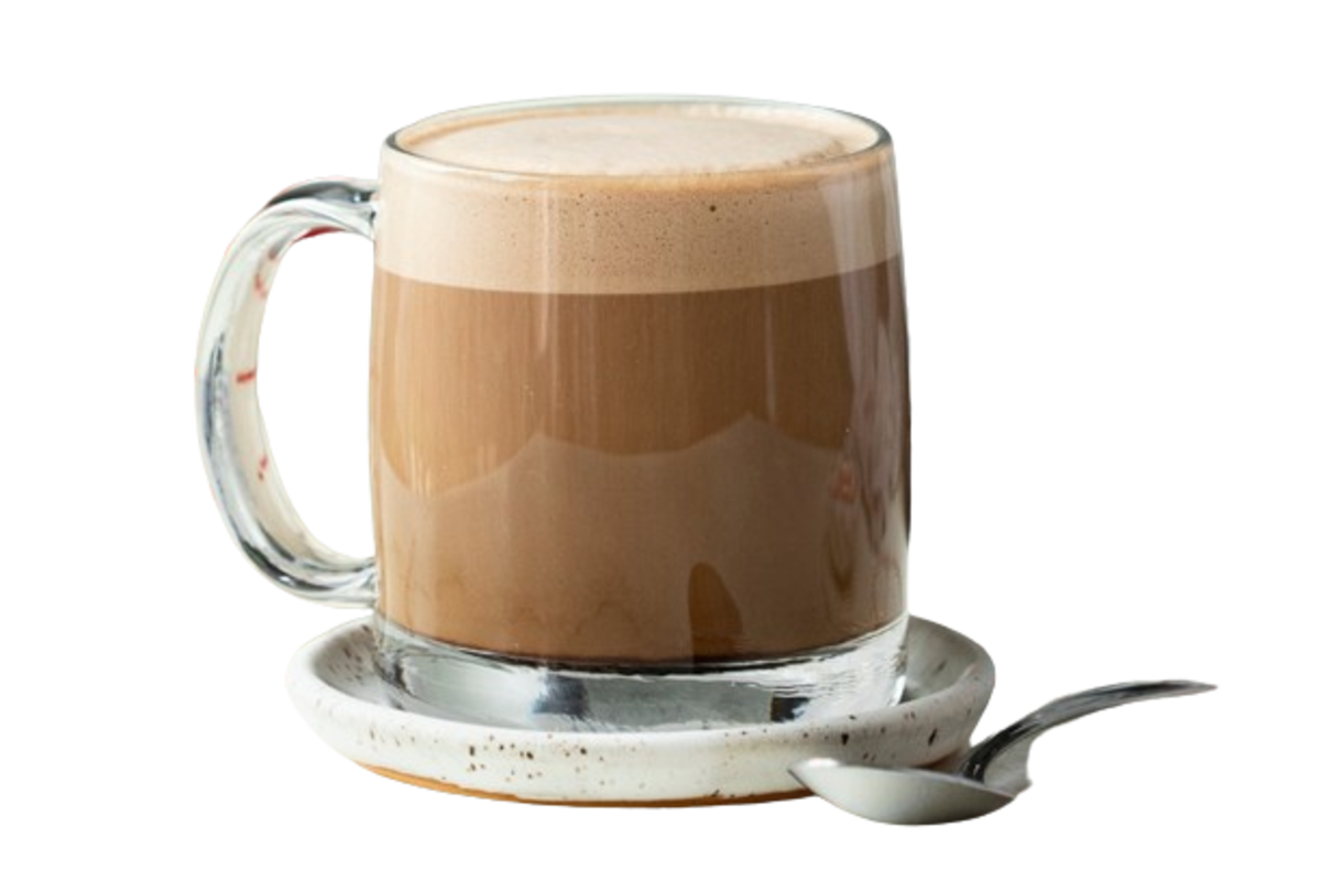 A glass mug of creamy mocha coffee on a ceramic saucer with a spoon, showcasing the rich blend of espresso, milk, and chocolate.