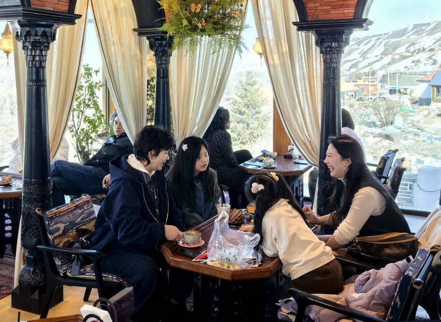 Customers enjoy coffee and their leisure time at a cafe in Baiyanggou Village in Urumqi County, northwest China's Xinjiang Uygur Autonomous Region, March 15, 2025. (Xinhua/He Xiaotong)