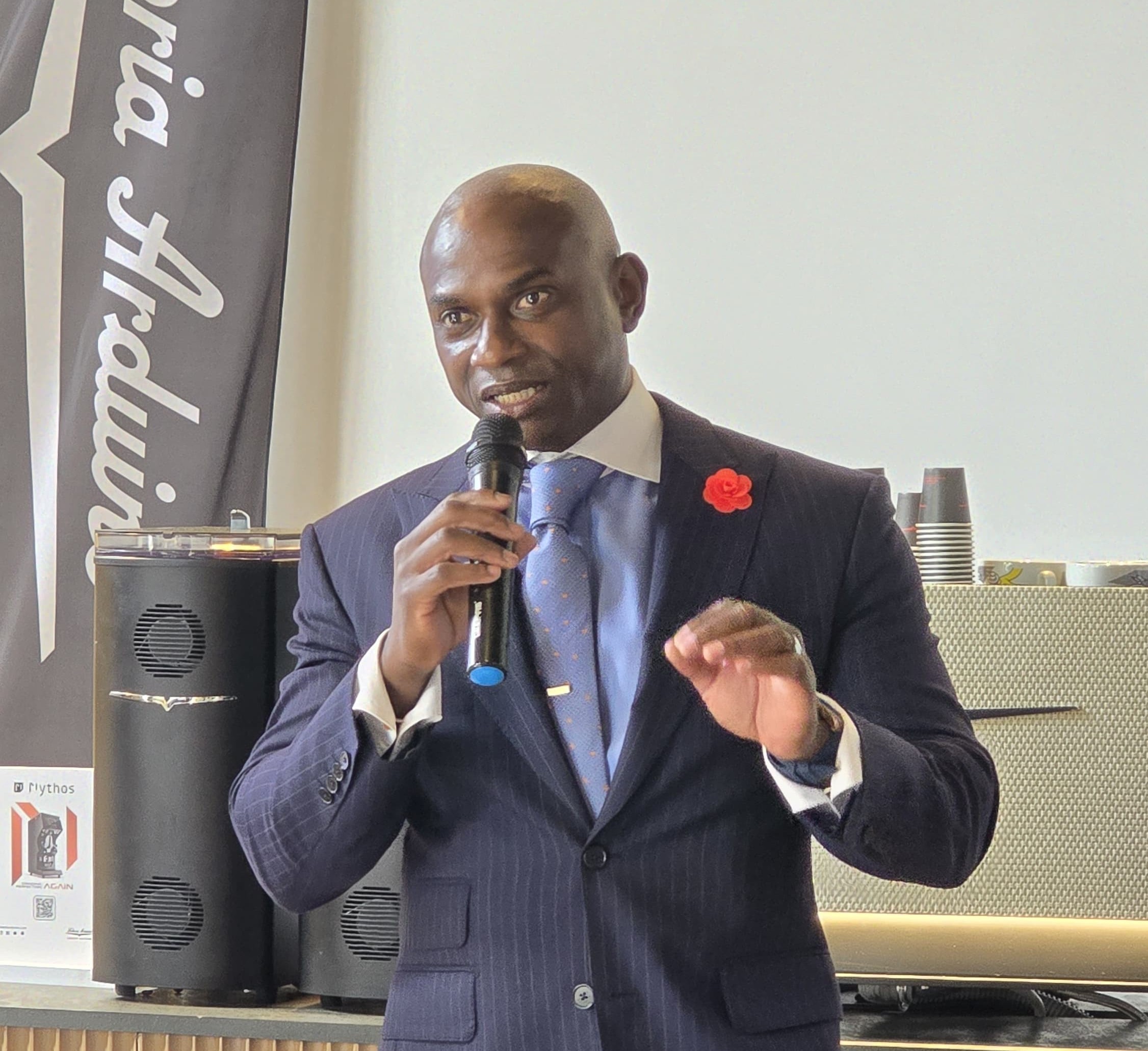 Mr. Garfield Kerr speaking at the UAE Coffee Innovation Summit in Dubai, holding a microphone while addressing the audience.