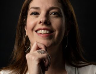 Cleia Junqueira smiling confidently, Brazilian coffee expert and Q-Grader, known for her work in coffee education and consulting across Brazil and the Middle East.