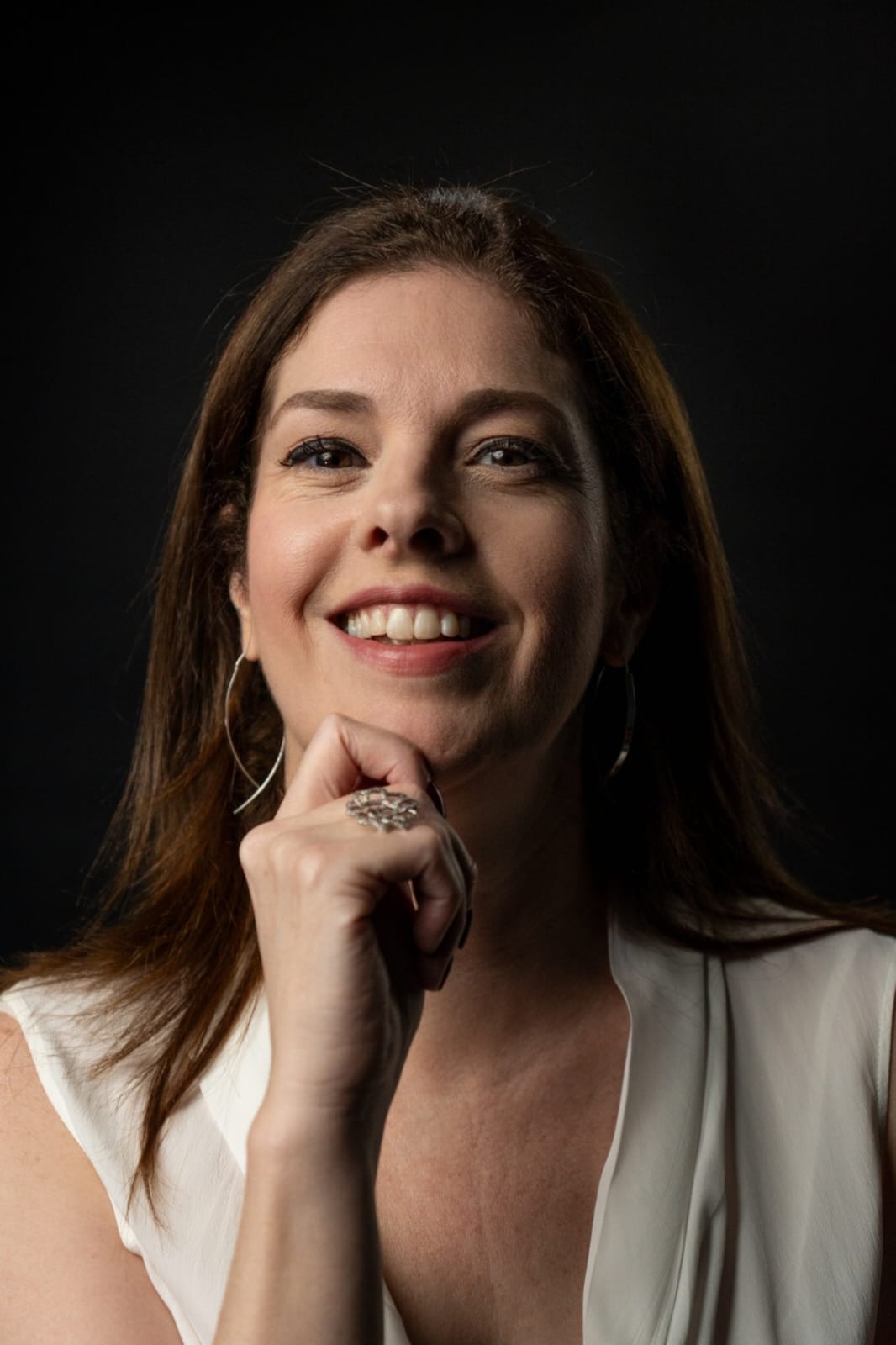 Cleia Junqueira smiling confidently, Brazilian coffee expert and Q-Grader, known for her work in coffee education and consulting across Brazil and the Middle East.