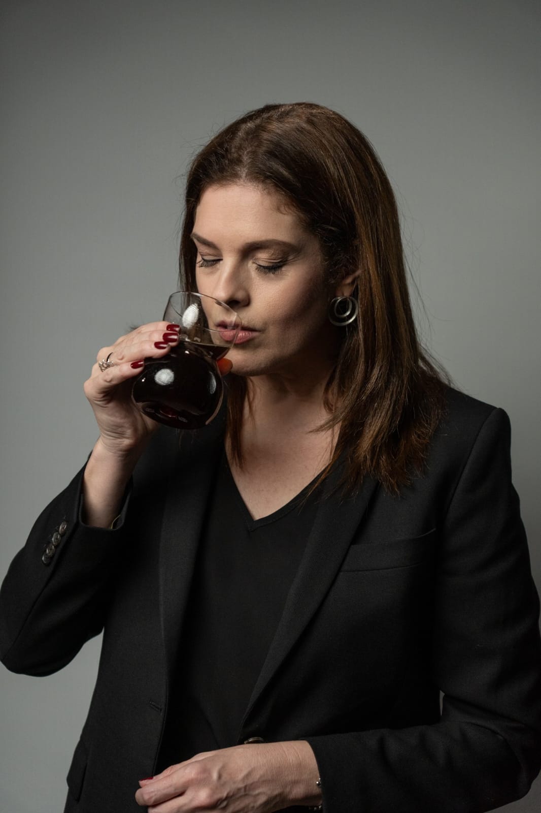 Cleia Junqueira evaluating a specialty coffee brew, showcasing her expertise as a certified Q-Grader and coffee consultant with nearly two decades of experience.