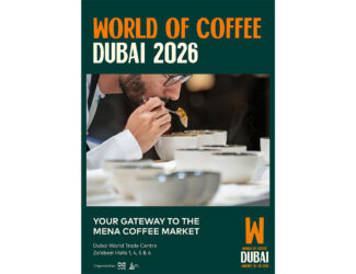 A coffee professional evaluates aroma and flavor at a cupping table, surrounded by steaming bowls during a coffee tasting session. The poster promotes “World of Coffee Dubai 2026” as the gateway to the MENA coffee market, with the event set to take place at the Dubai World Trade Centre from January 18–20, 2026