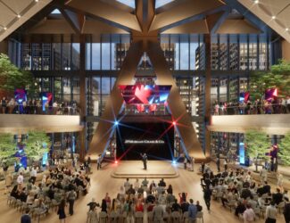 Interior view of JPMorgan Chase’s new headquarters at 270 Park Avenue, showing a large atrium with a stage, audience seating, indoor trees, and modern design elements, with employees gathered on multiple levels.