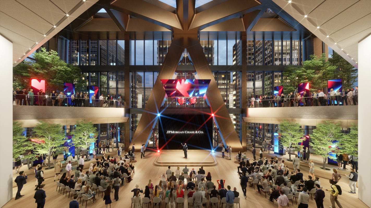 Interior view of JPMorgan Chase’s new headquarters at 270 Park Avenue, showing a large atrium with a stage, audience seating, indoor trees, and modern design elements, with employees gathered on multiple levels.