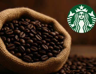 A burlap sack filled with dark roasted coffee beans sits on a wooden surface, with the Starbucks logo displayed in the top right corner.