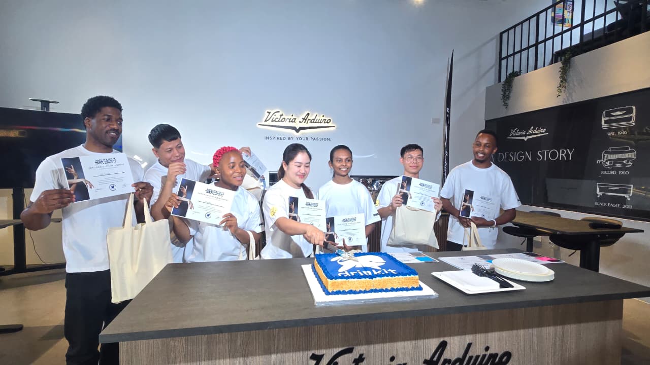 The winners and participants of the Drinkit Barista Championship 2025 in Dubai celebrating with certificates and a Drinkit cake at Victoria Arduino Experience Center.