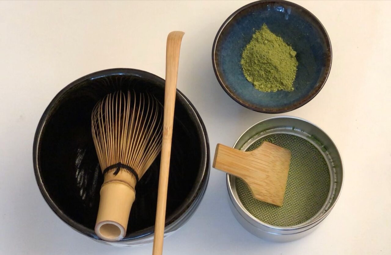 A barista prepares a bright green bowl of matcha, symbolizing wellness, ritual, and modern hospitality trends.