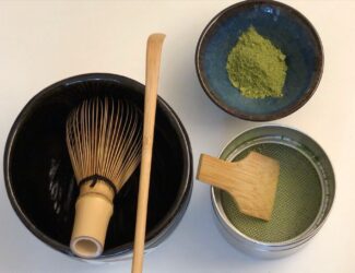 A barista prepares a bright green bowl of matcha, symbolizing wellness, ritual, and modern hospitality trends.