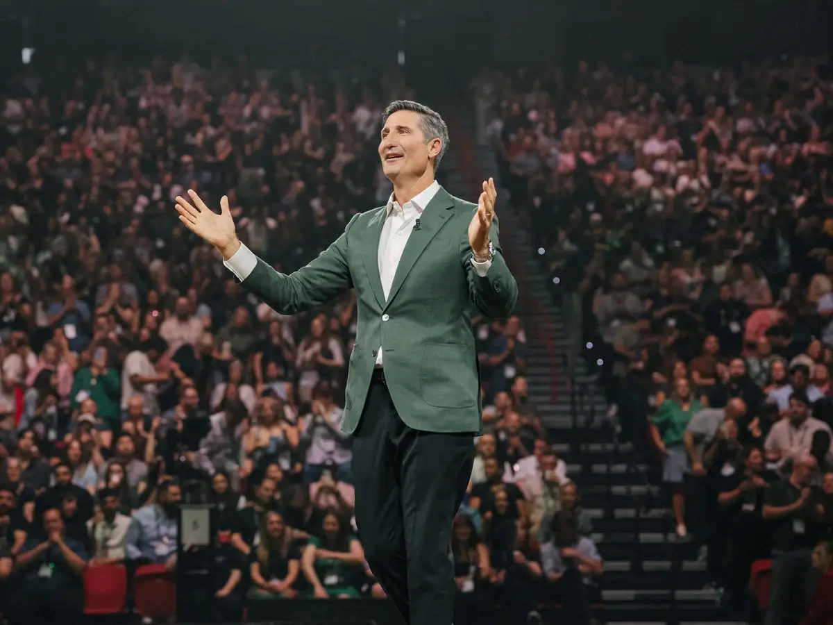 Brian Niccol, CEO of Starbucks, speaking on stage in front of a large audience