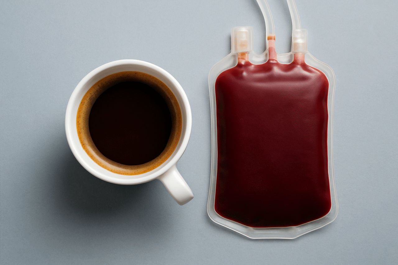 A white ceramic cup filled with coffee sits next to a sealed blood donation bag, symbolizing the link between caffeine consumption and donor blood quality.