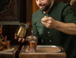 Mahmoud Izachman prepares traditional coffee with care, using a copper cezve over hot sand in a warm, wood-decorated setting — a moment that reflects the artistry and heritage of Palestinian coffee culture.