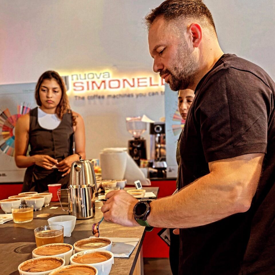 Mahmoud Izachman participates in a professional coffee cupping session, carefully tasting and evaluating different brews — a moment reflecting his expertise and dedication to specialty coffee education.