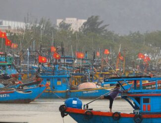 Fishing boats anchored in Vietnam as heavy rain and wind from Typhoon Kalmaegi approach, highlighting the storm’s regional impact.
