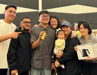 Neil Golez, surrounded by friends and supporters, smiles while holding his AeroPress trophy after being crowned UAE AeroPress Champion 2025 in Dubai.